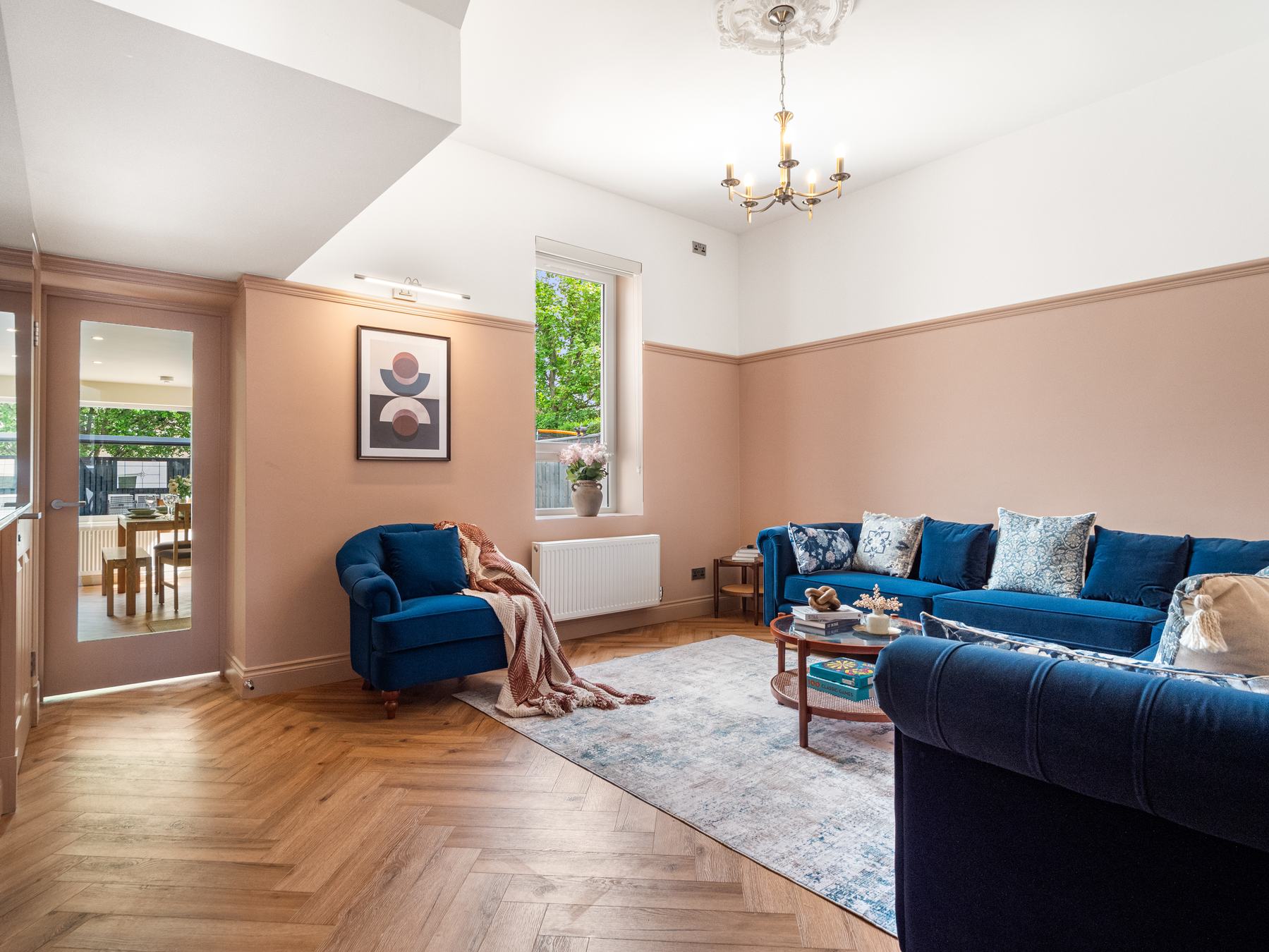 Luxury living room photography with blush walls and a blue velvet sofa