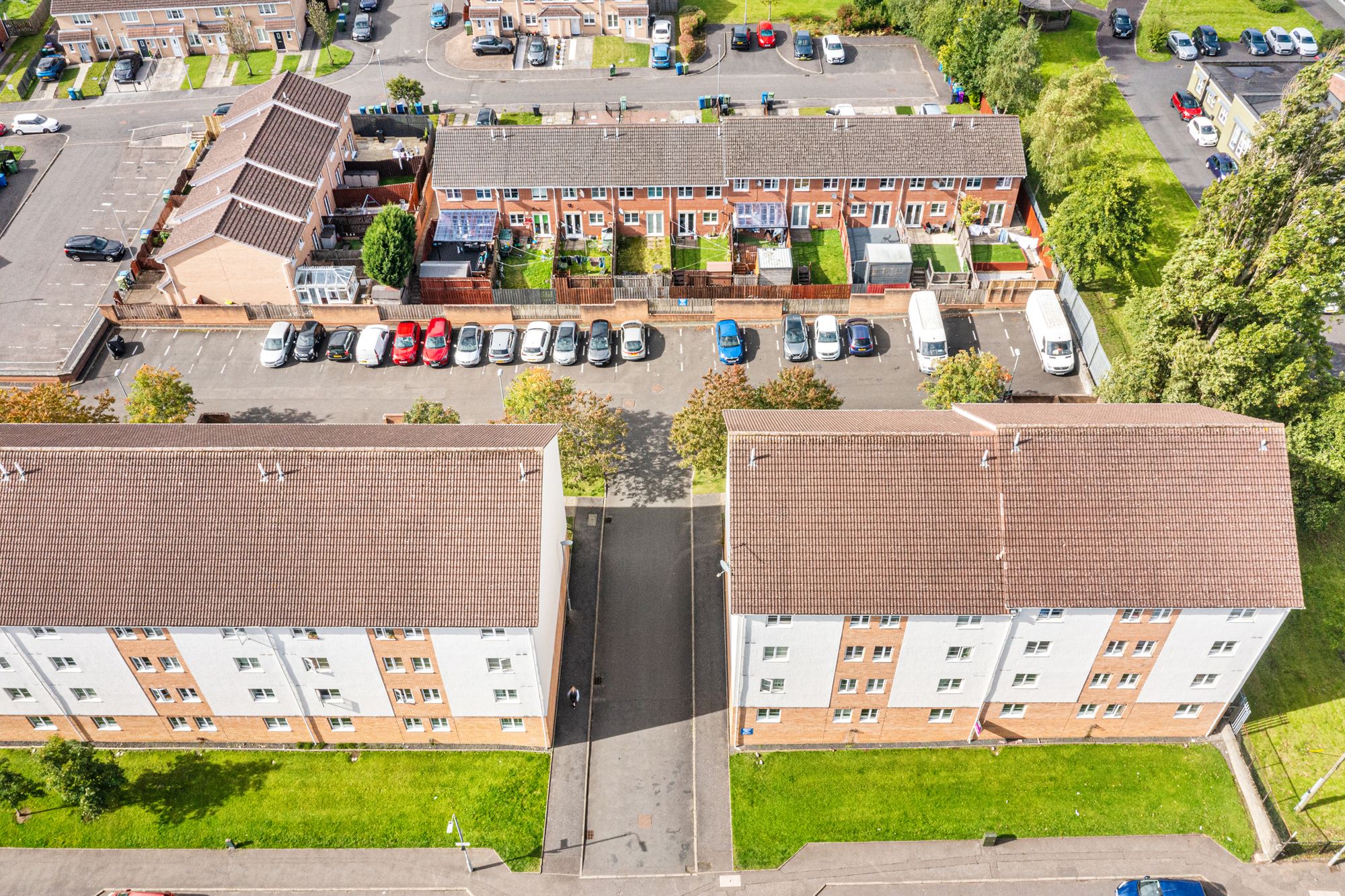 Aerial drone photograph of a brick housing estate and parking area