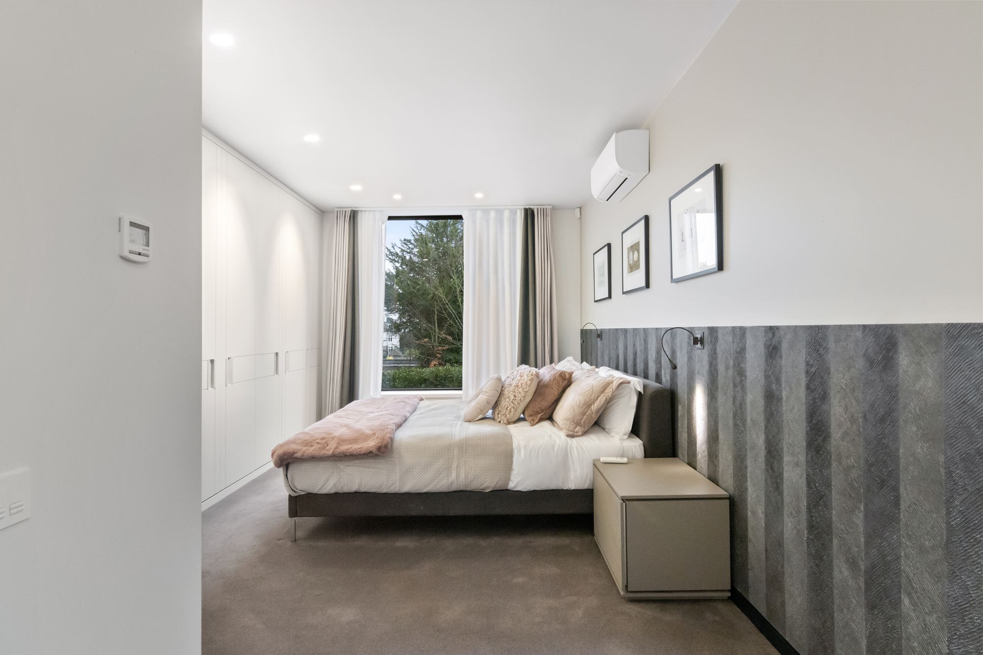 Bedroom in neutral tones with fitted wardrobes