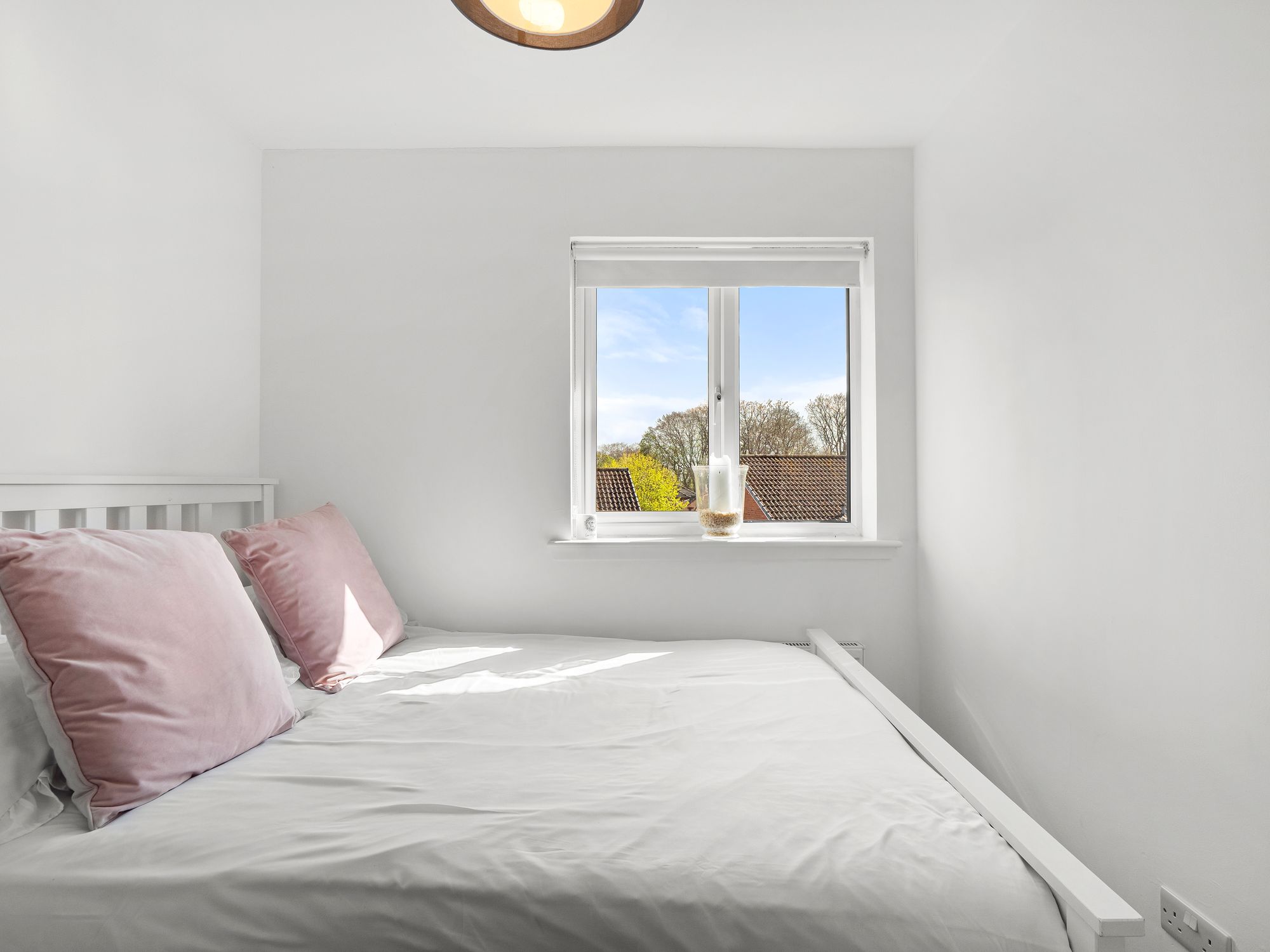 Bright bedroom with pink velvet cushions