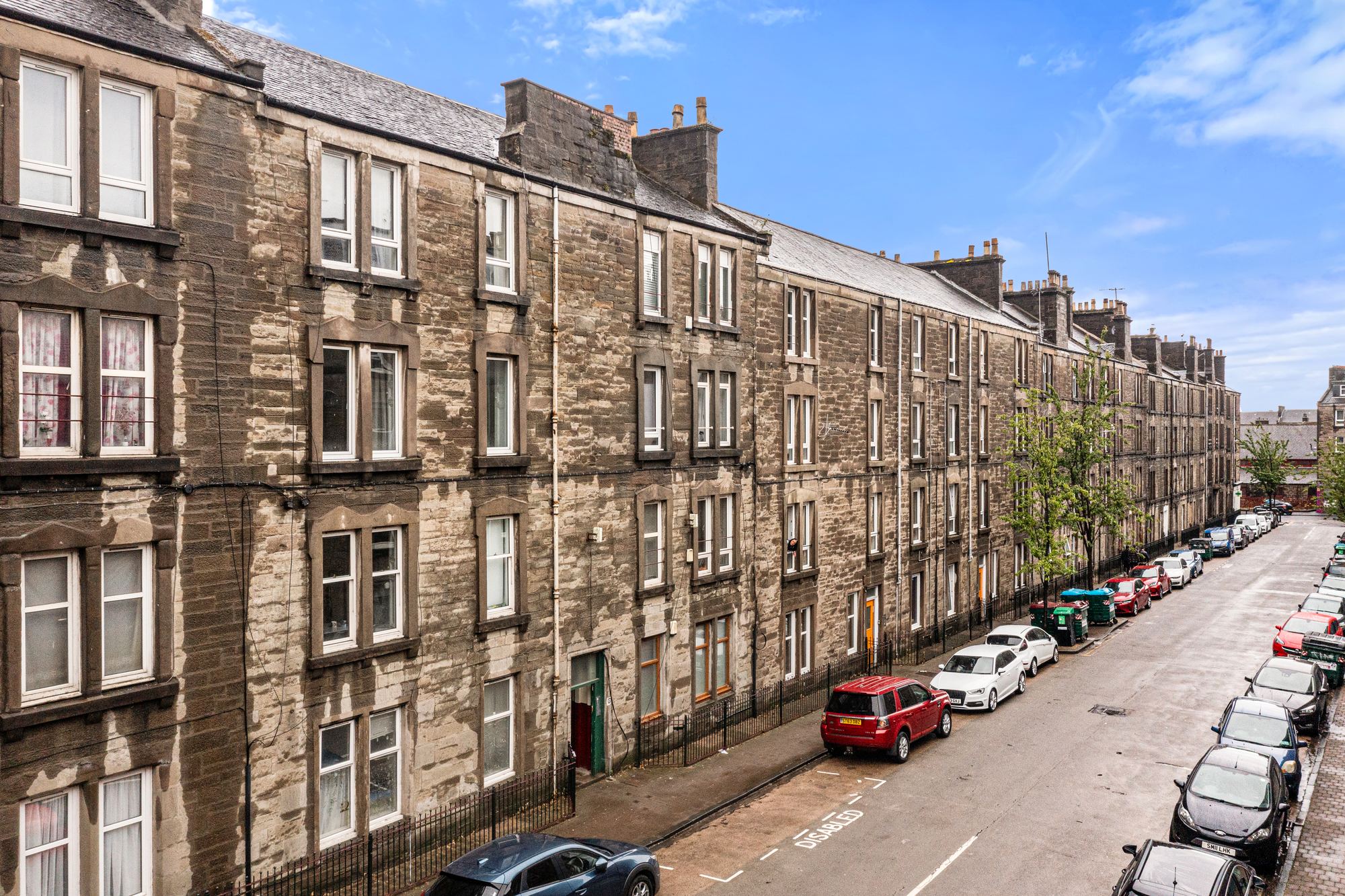 Row of sandstone tenement buildings on a Dundee street