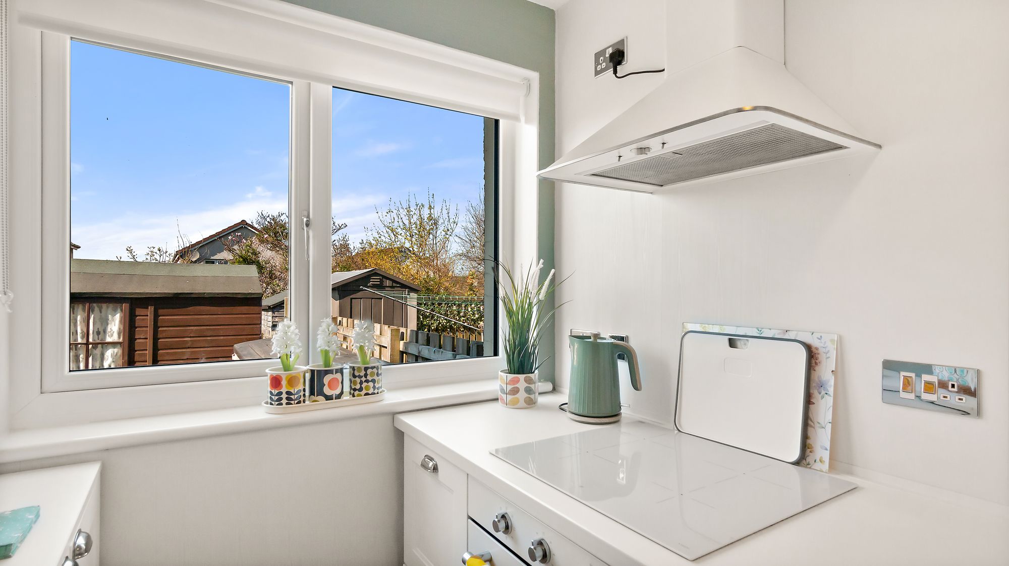 Kitchen counter detail with extractor hood and window view