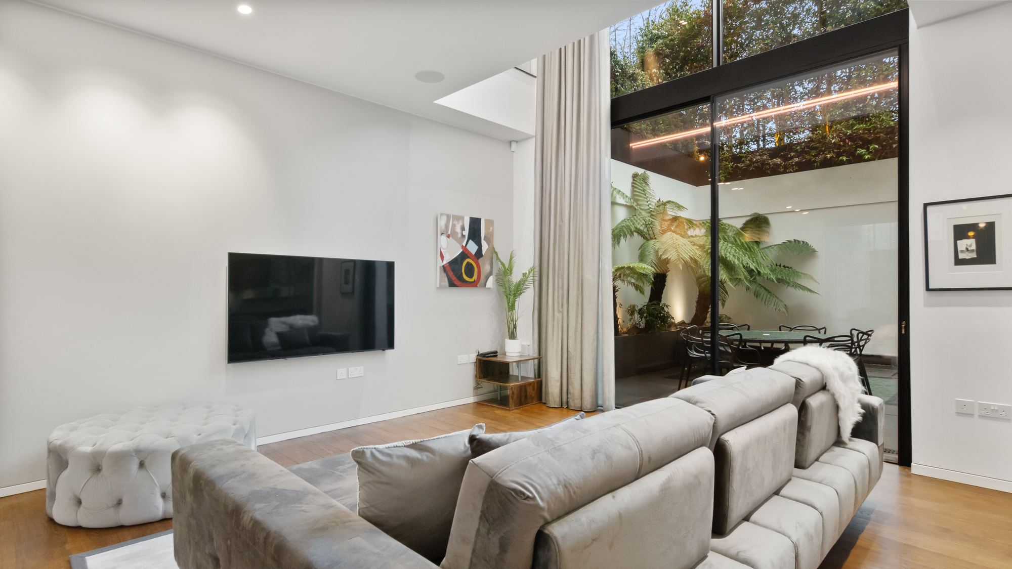 Living room opening onto internal courtyard with palms