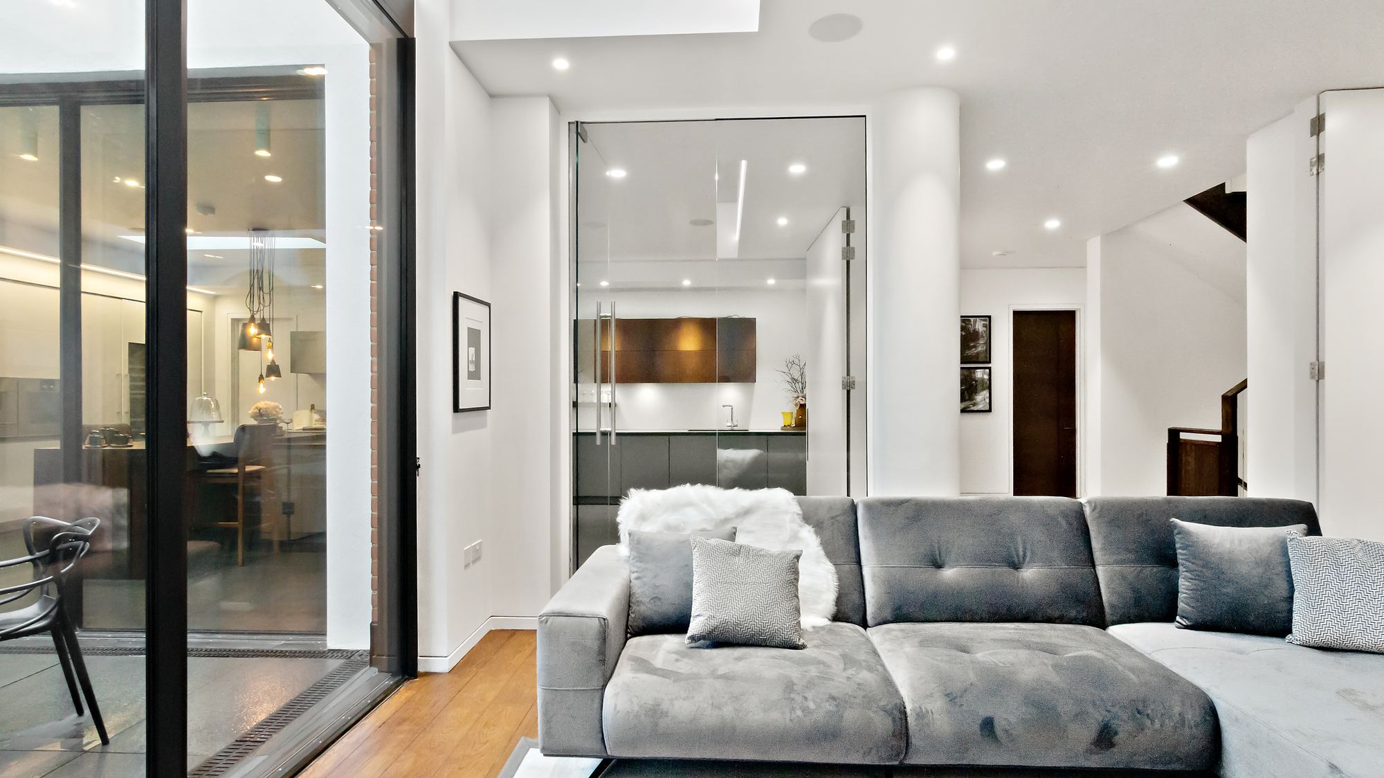Living room with glimpse into glass-walled kitchen