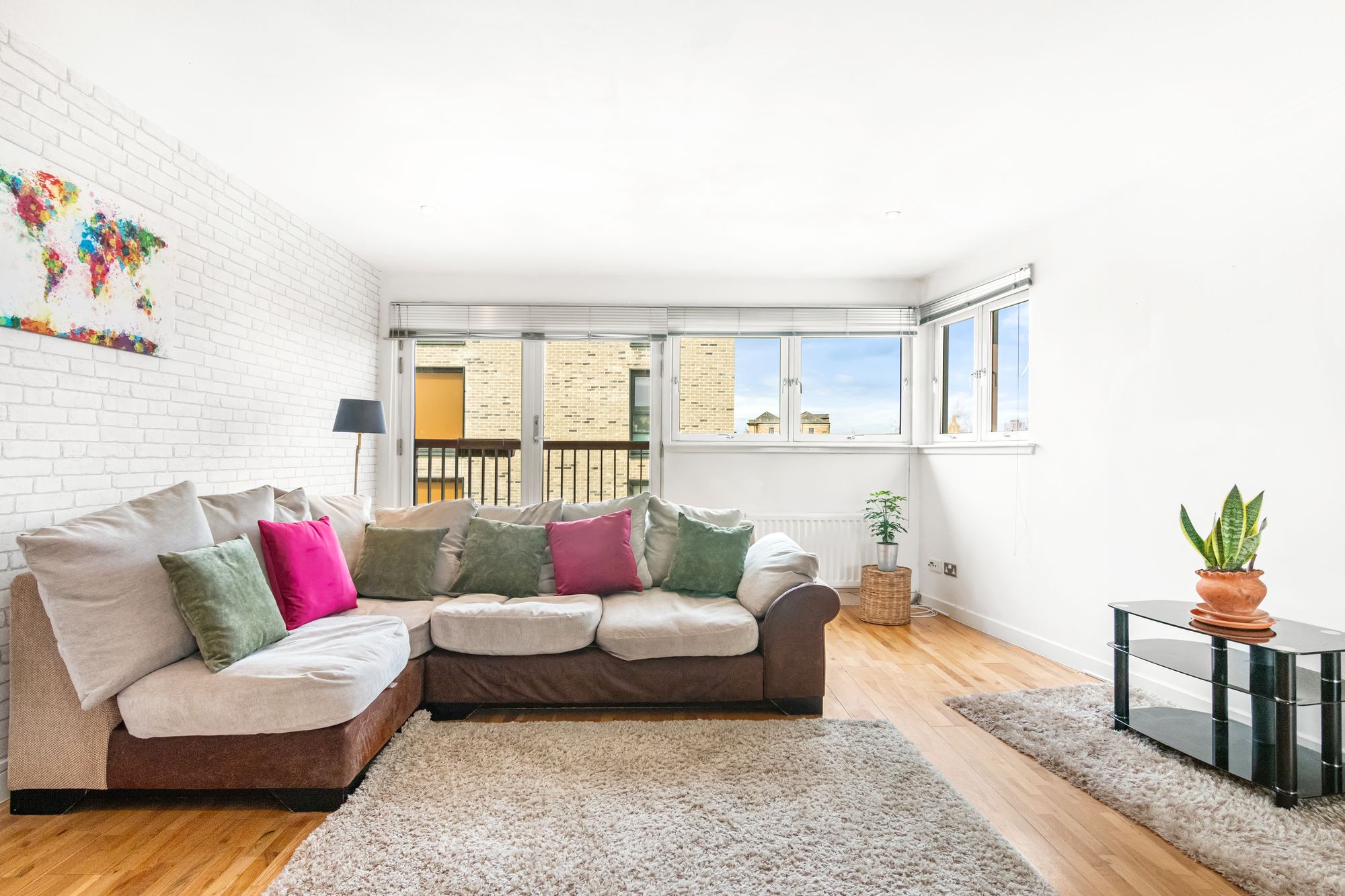 Living room with white brick feature wall and colourful artwork