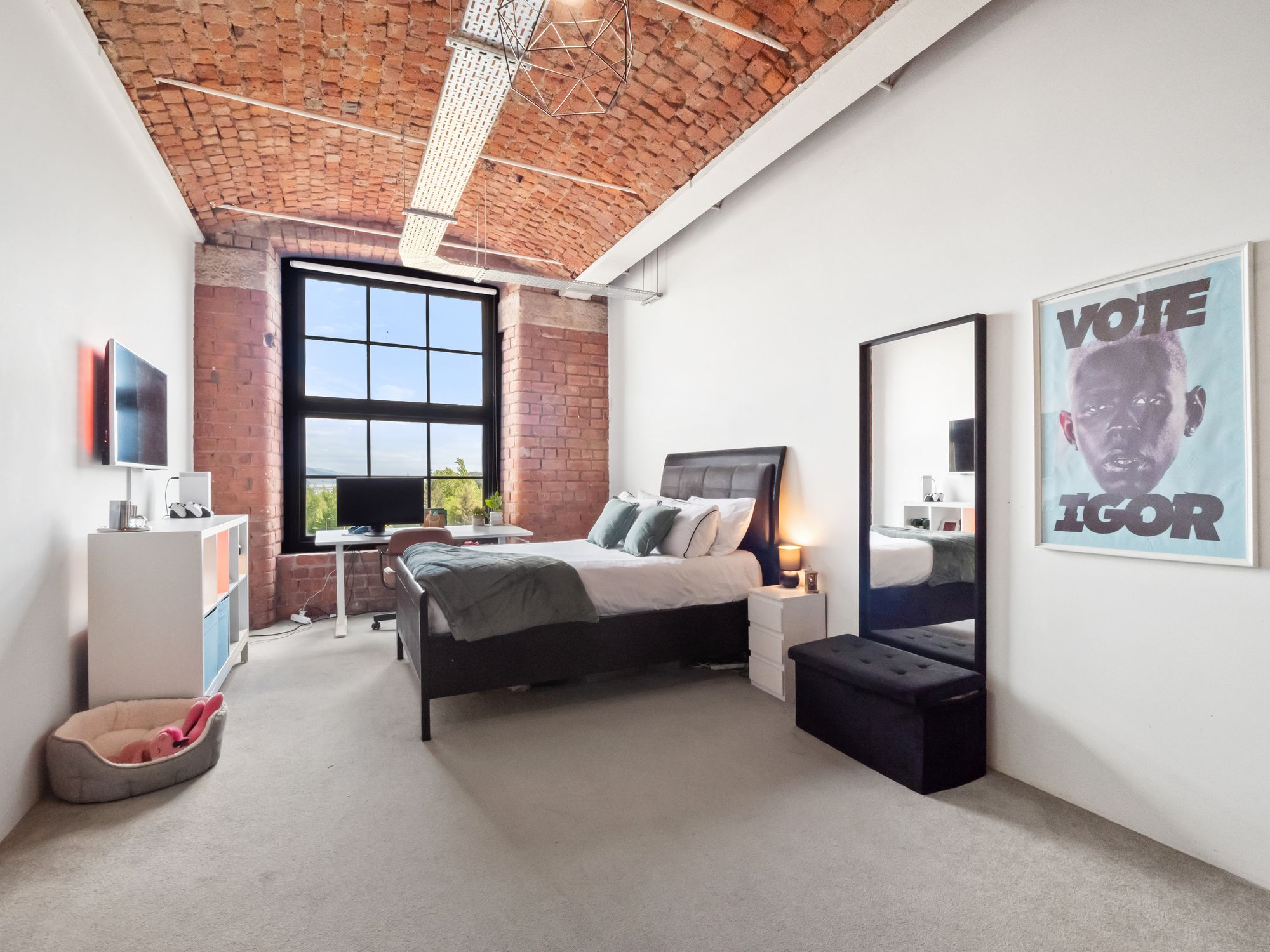 Loft bedroom with exposed brick and vaulted ceiling