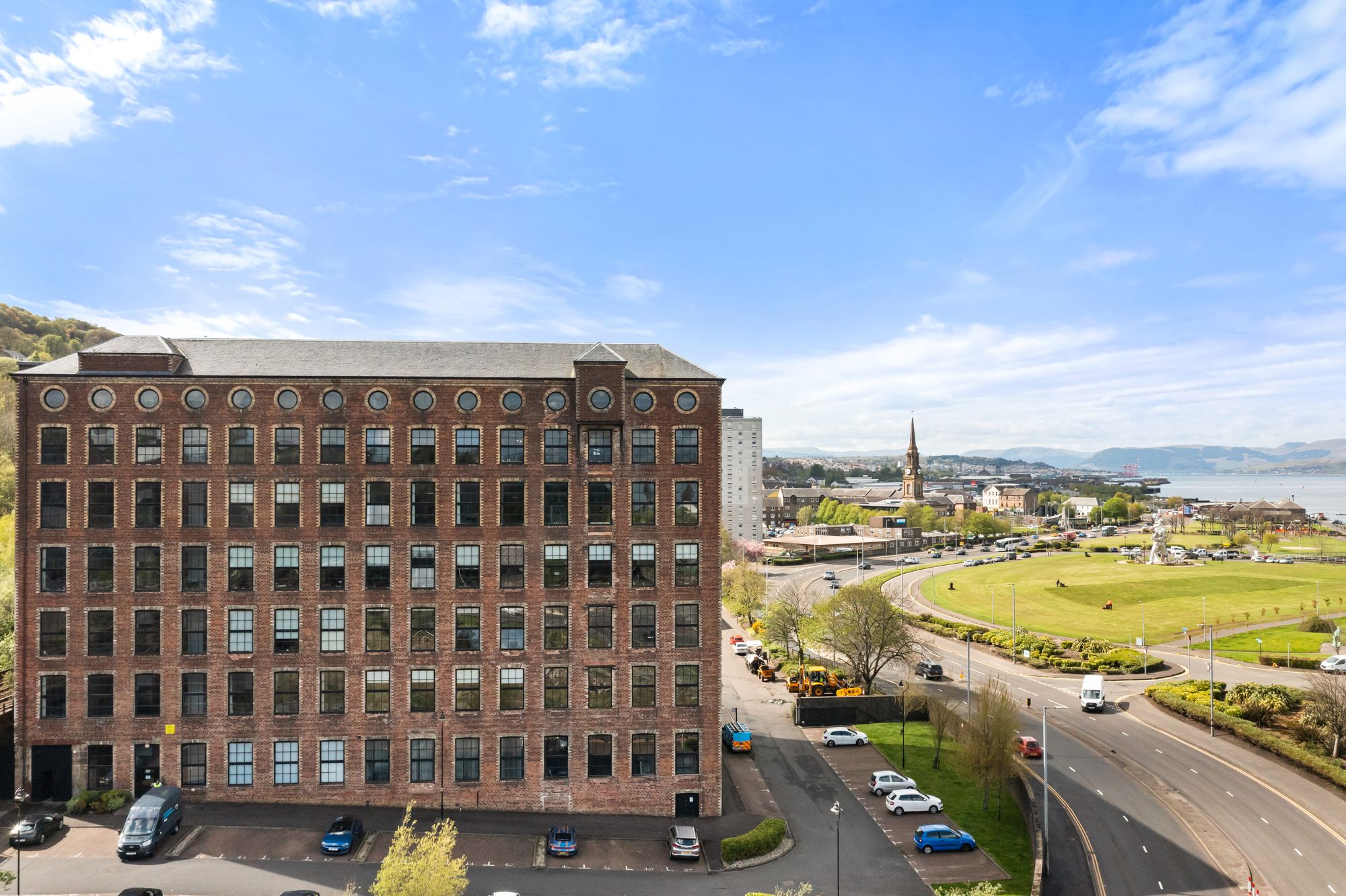 Elevated view of a converted mill building with coastal backdrop