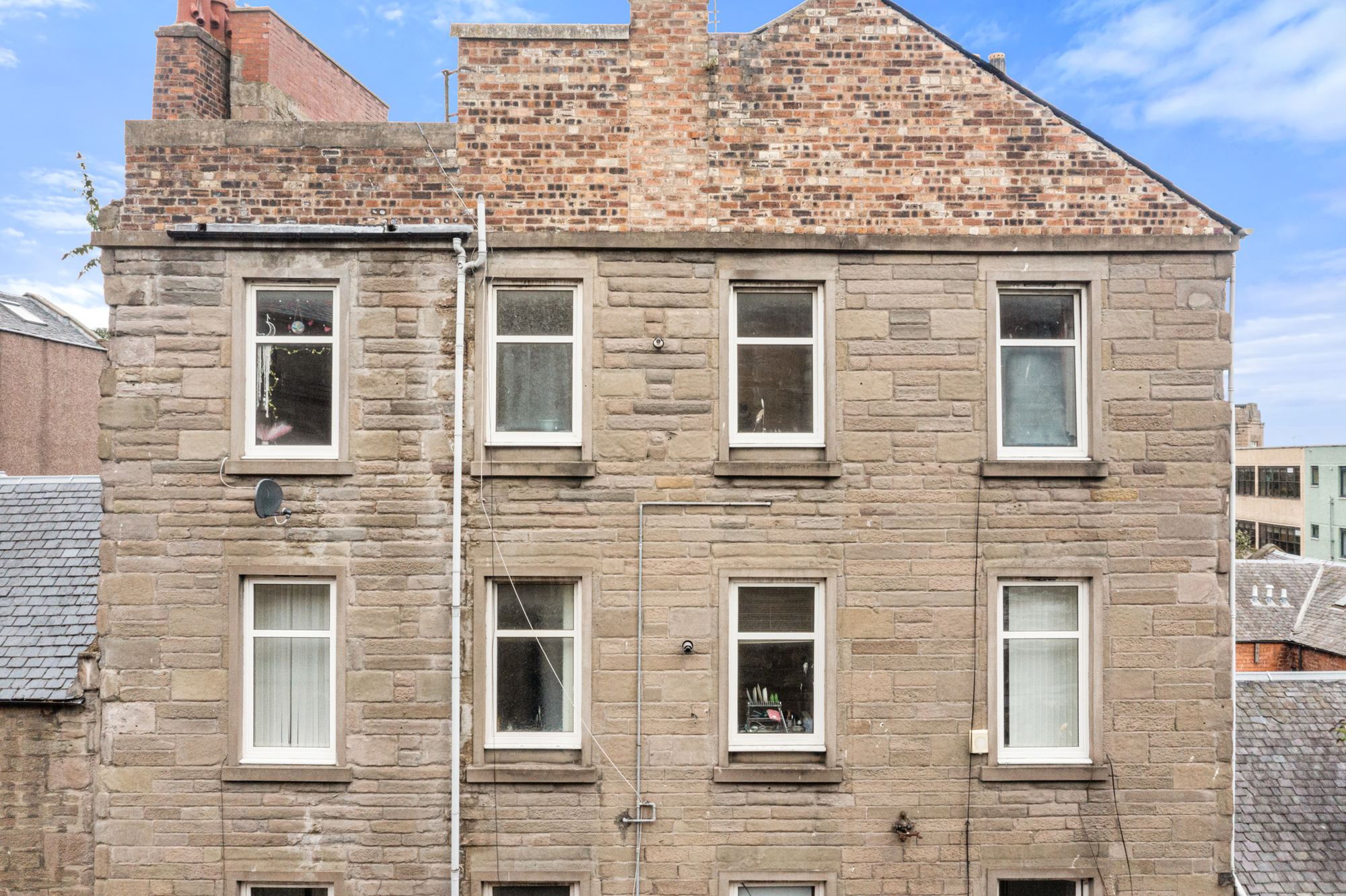 Detail of a sandstone tenement facade with sash windows
