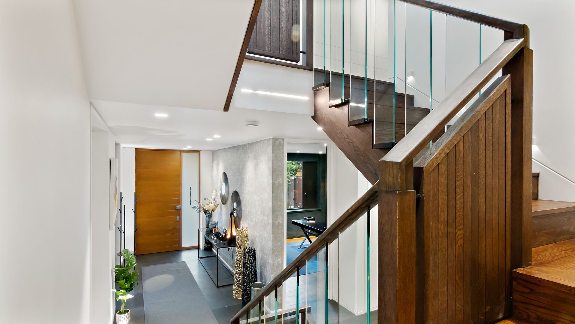 Entrance hall with oak staircase and glass balustrade