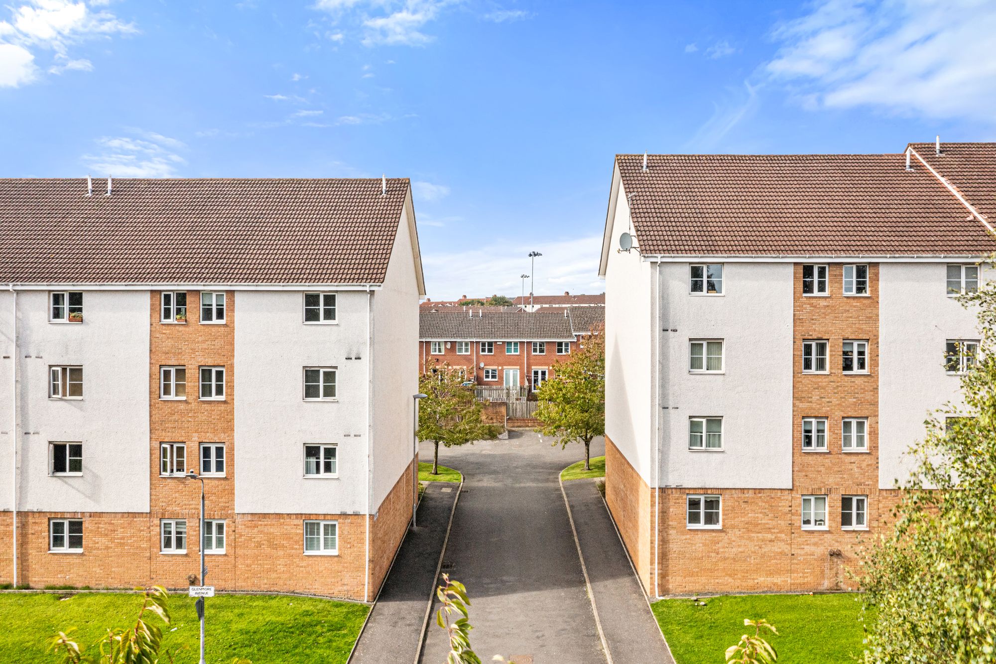 Twin apartment blocks either side of a courtyard path