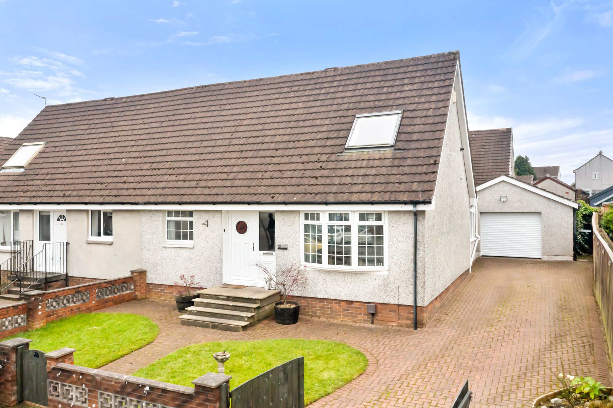 White rendered bungalow exterior with driveway